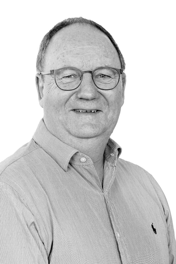 Portrætfoto i sort/hvid af salgskonsulent i Lithomex Benny Villekjær Pedersen i lys stribet skjorte på hvid baggrund