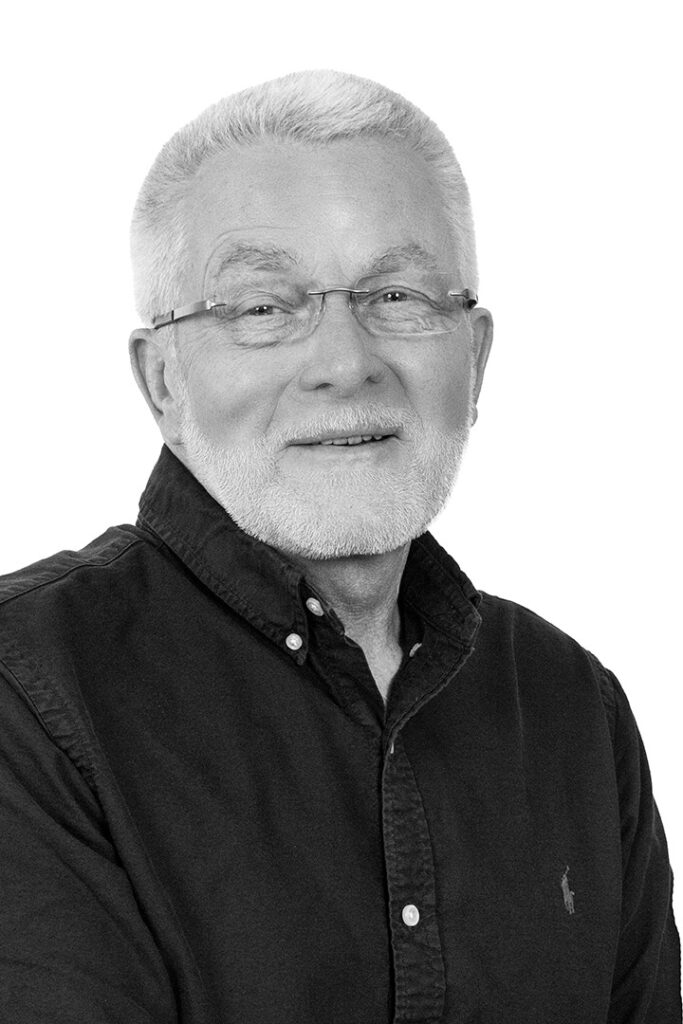 Portrætfoto i sort/hvid af salgskonsulent i Lithomex Thomas Kristensen i sort skjorte på hvid baggrund